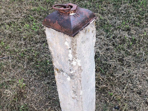 Old hitching post in front of a house 