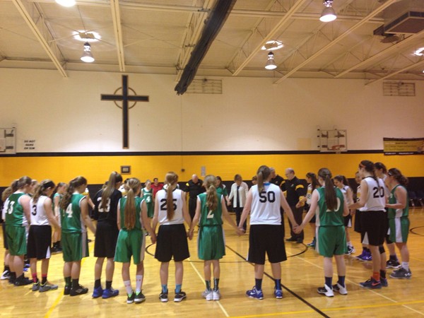 Opposing teams praying after their basketball games at Our Lady of Lourdes Catholic School