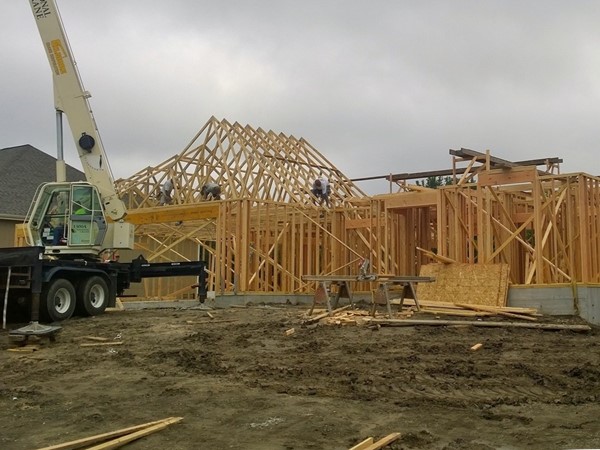 New custom home takes shape with roof trusses being installed