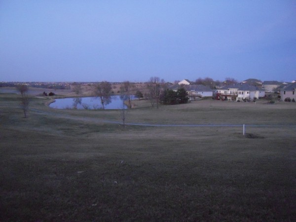 View of one of the fairways with a pond surrounded by homes