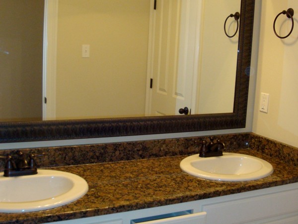 Elegant bathroom upgrades include granite counters and framed mirrors.