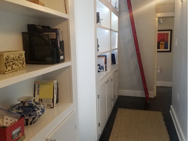 Creative hallway storage in KC homes - shelves, rope lighting, and a track ladder