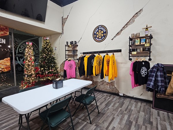 The Axe Shedd retail and seating area, featuring branded merchandise and holiday decor.