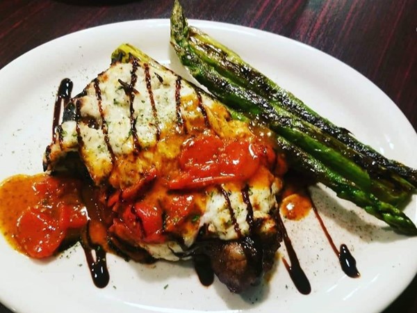 The Outrigger: Blackened NY strip steak topped with baked crab and a cherry tomato reduction