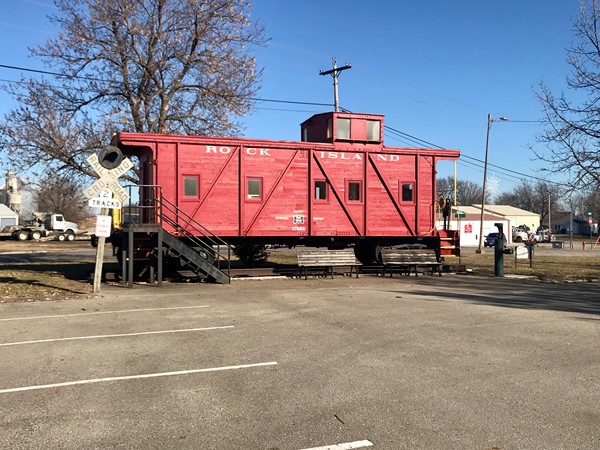 A neat old Rock Island caboose sits in a park area in downtown Baxter