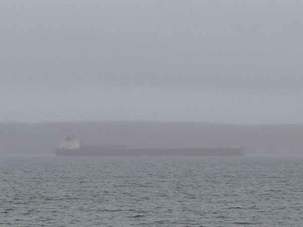The fog lifting off the Little Traverse Bay to reveal a thousand footer taking shelter from a storm