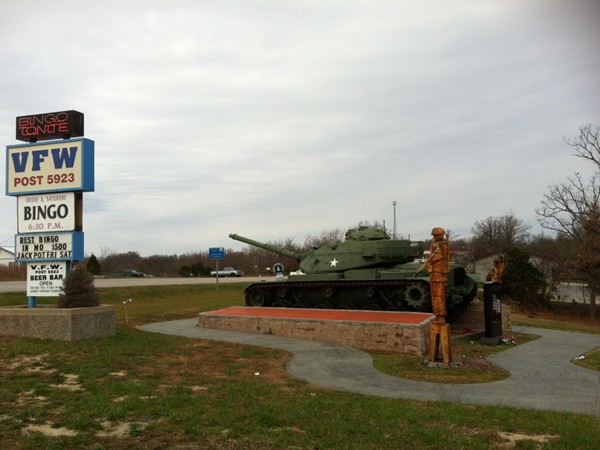 A tank and sculpture on display in front of V.F.W. Post 5923
