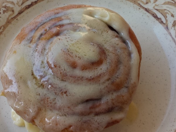 Enjoy fresh fruit and a heavenly cinnamon roll from Another Broken Egg