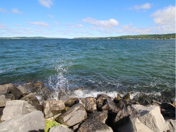 Lake Charlevoix's freshwater splashing up on the rocks, looking out from the Marina