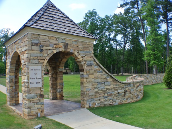 A stone wall entrance adds an extra touch of elegant character to The Townes of North River
