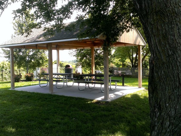 Several picnic tables and shelters next to pool and playground