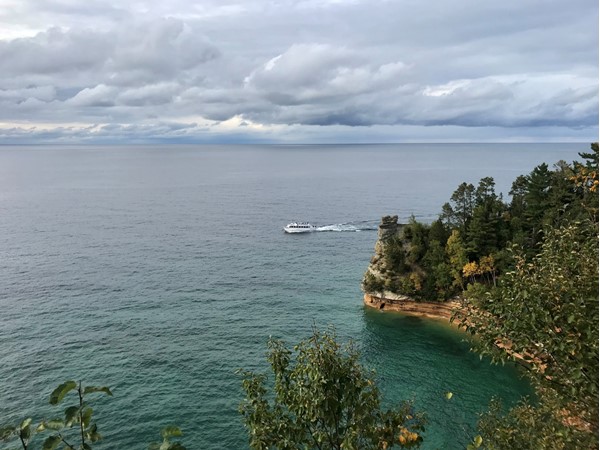 Hiking along Pictured Rocks Lakeshore as a tour boat goes by