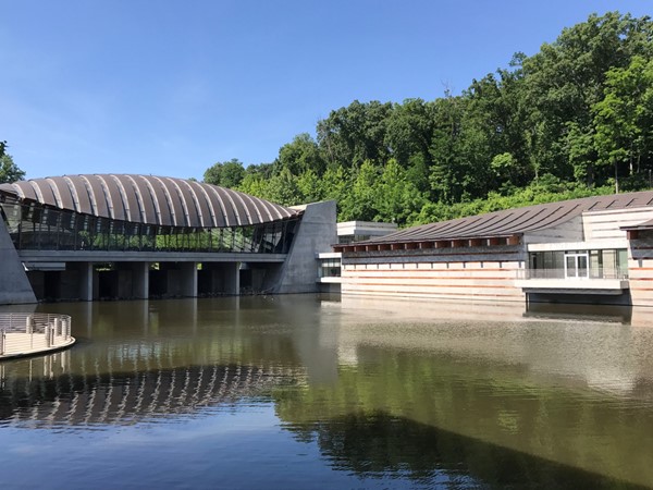 The reflections in the water of the copper roof of Crystal Bridges Museum 