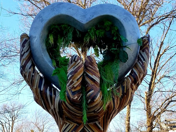 Unique and soulful art, Stone Heart in Wooden Hands sculpture, located in Lawrence Plaza
