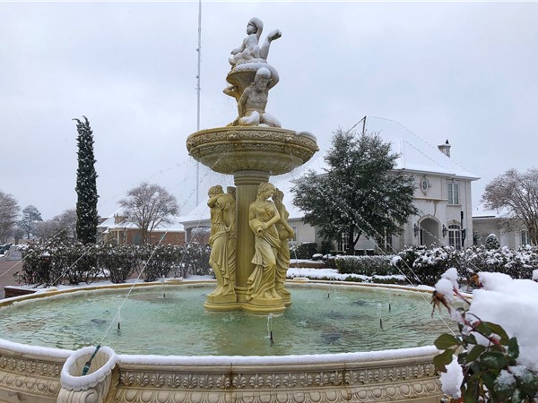 With gentle snow falling, the fountain at Maison Orleans in Monroe looks frosty