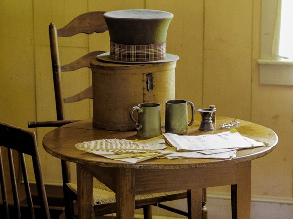 A hat and mugs on a table in an exhibit at the Old State House
